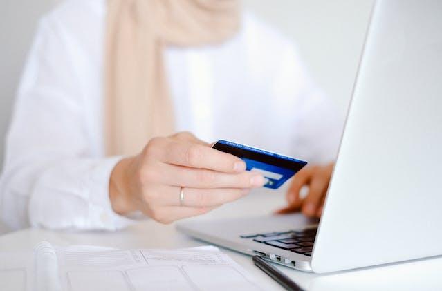 A person paying rent online with a card.