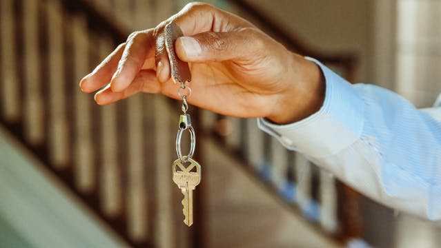 a hand holding a key inside a house